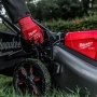Milwaukee M18 FUEL™ 53 cm selvkørende plæneklipper. Miljøbilledet viser produktets funktioner.