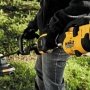 Dewalt græstrimmer DCMAS5713X1-QW. Med en 54 V motor og et 9,0 Ah batteri. Miljøbilledet viser produktets håndgreb.