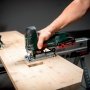 En person bruger et trådløst Metabo stiksav til at lave et præcist snit i et træstykke fra oven