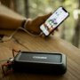 Nebo Rambler 20.000 mAh powerbank. Miljøbilledet viser produktet i brug med telefon.