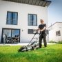 En mand klipper græs med en trådløs plæneklipper fra Metabo, model RM 36-18.