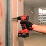 Milwaukee M18 BLPDRC-422C slagboremaskine, en kompakt og kraftfuld kulfri løsning med 145 mm længde til nem adgang i snævre områder. Billedet er et miljøbillede, hvor produktet bliver brugt i forbindelse med træ.