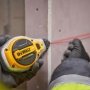 Dewalt kridtsnor 6:1, 30 m, rød kridt. Miljøbilledet viser produktet i brug på væg.