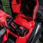 Milwaukee M18 FUEL™ 53 cm selvkørende plæneklipper. Miljøbilledet viser produktets opbevaring af batterier.
