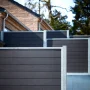 Høgild komposithegn i koksgrå med træstruktur og galvaniseret stolpe til haven og terrassen