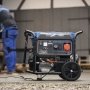 Scheppach generator SG7100X 5400W. Miljøbilledet viser produktet i brug udendørs.