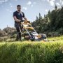 Dewalt DCMWSP660N-XJ plæneklipper. Miljøbilledet viser produktet i brug.
