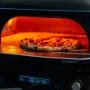 Gozney Dome Gen 2.0 fronthylde. Miljøbilledet viser produktets anvendelighed ved pizzabagning.