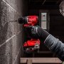 Milwaukee M18 BLPDRC-422C slagboremaskine, en kompakt og kraftfuld kulfri løsning med 145 mm længde til nem adgang i snævre områder. Billedet er et miljøbillede af produktet i brug.