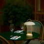 Nordlux Mirano portable bordlampe beige. Miljøbilledet viser produktet udenfor.