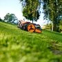 Worx WR202E Landroid Vision M250 robotplæneklipper er en effektiv løsning med avanceret teknologi til græsarealer på op til 250 m². Billedet er et miljøbillede, hvor produktet kører ned ad en bakke