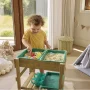 Hape multifunktionelt legebord. Produkt vises med model i indendørs miljø